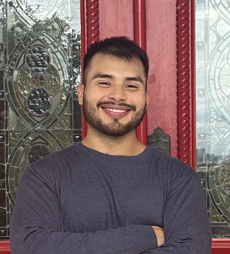 Ryan Aparicio standing in front of an ornate red doorway